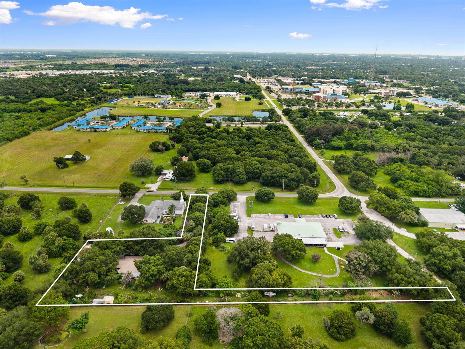 An aerial view shows a large, L-shaped property outlined in white, featuring buildings and trees — 3603 Kirby Loop Road, Fort Pierce FL 34981, FORT PIERCE, FL