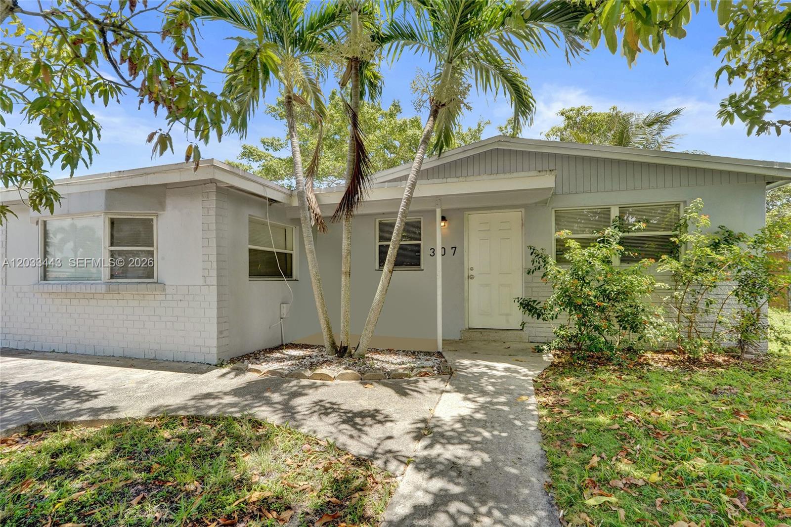 A single-story house with light gray walls, a white front door, and palm trees — 307 NW 11th Ave, Delray Beach FL 33444, DELRAY BEACH, FL