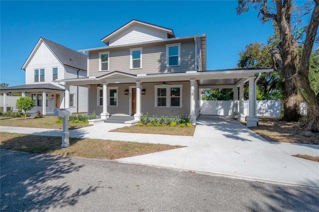 A two-story house with light brown siding, a front porch, and an attached carport — 804 E WILDER AVENUE, TAMPA, FL