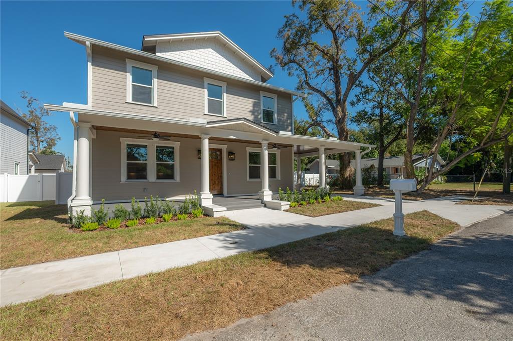 A two-story house with light brown siding, a covered front porch, and white columns — 804 E WILDER AVENUE, TAMPA, FL