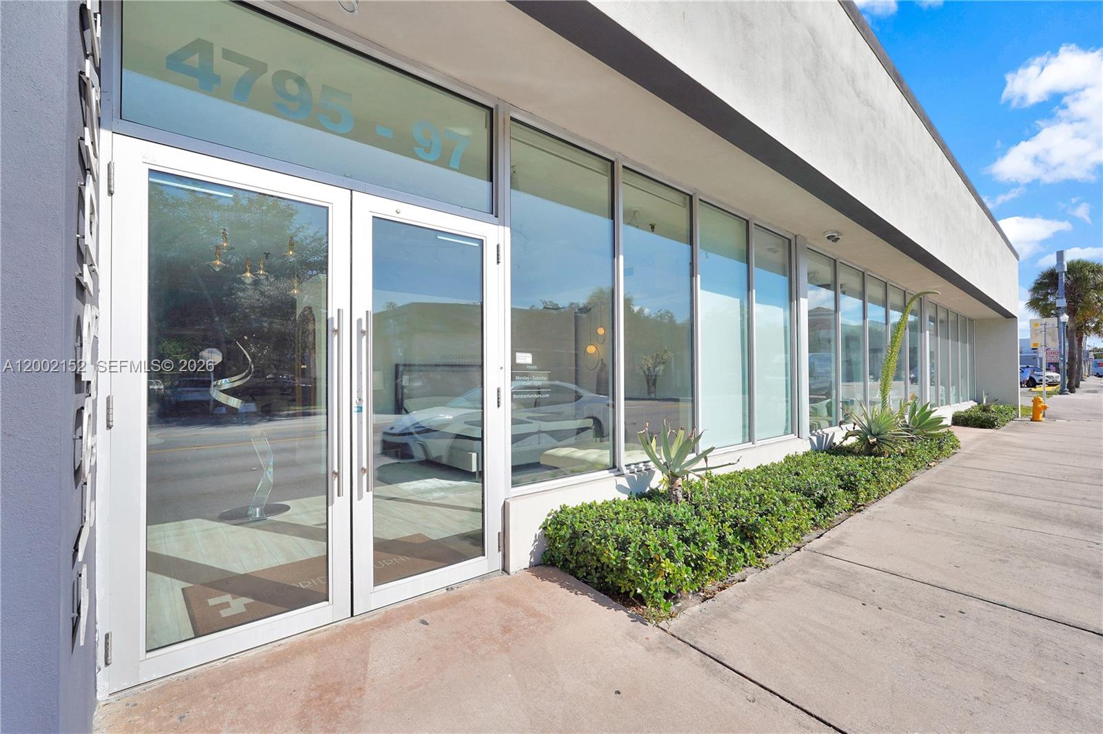 The exterior of a commercial storefront features glass double doors and large display windows — 4797 SW 8th St, Miami FL 33134, MIAMI, FL