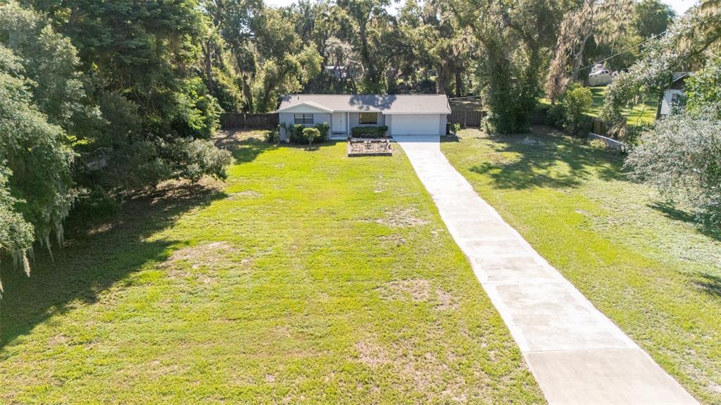An aerial view shows a single-story house with a long concrete driveway and large yard — 8214 VALRIE LANE, RIVERVIEW, FL