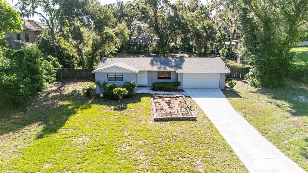 An aerial view of a single-story house with a gray exterior, garage, and front patio — 8214 VALRIE LANE, RIVERVIEW, FL
