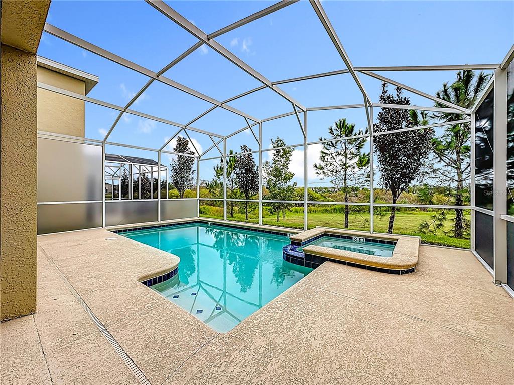 An aerial view shows suburban houses with screened-in pools and backyards in a residential neighborhood — 791 DROP SHOT DRIVE, DAVENPORT, FL