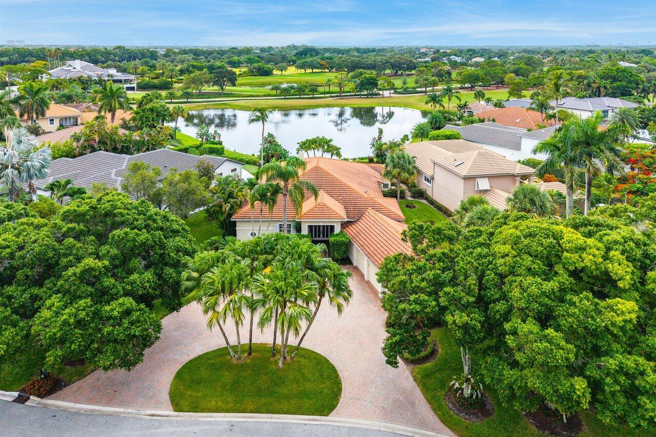 An aerial view of a suburban house with a tile roof, circular driveway, and lake — 118 W Village Way, Jupiter FL 33458, JUPITER, FL
