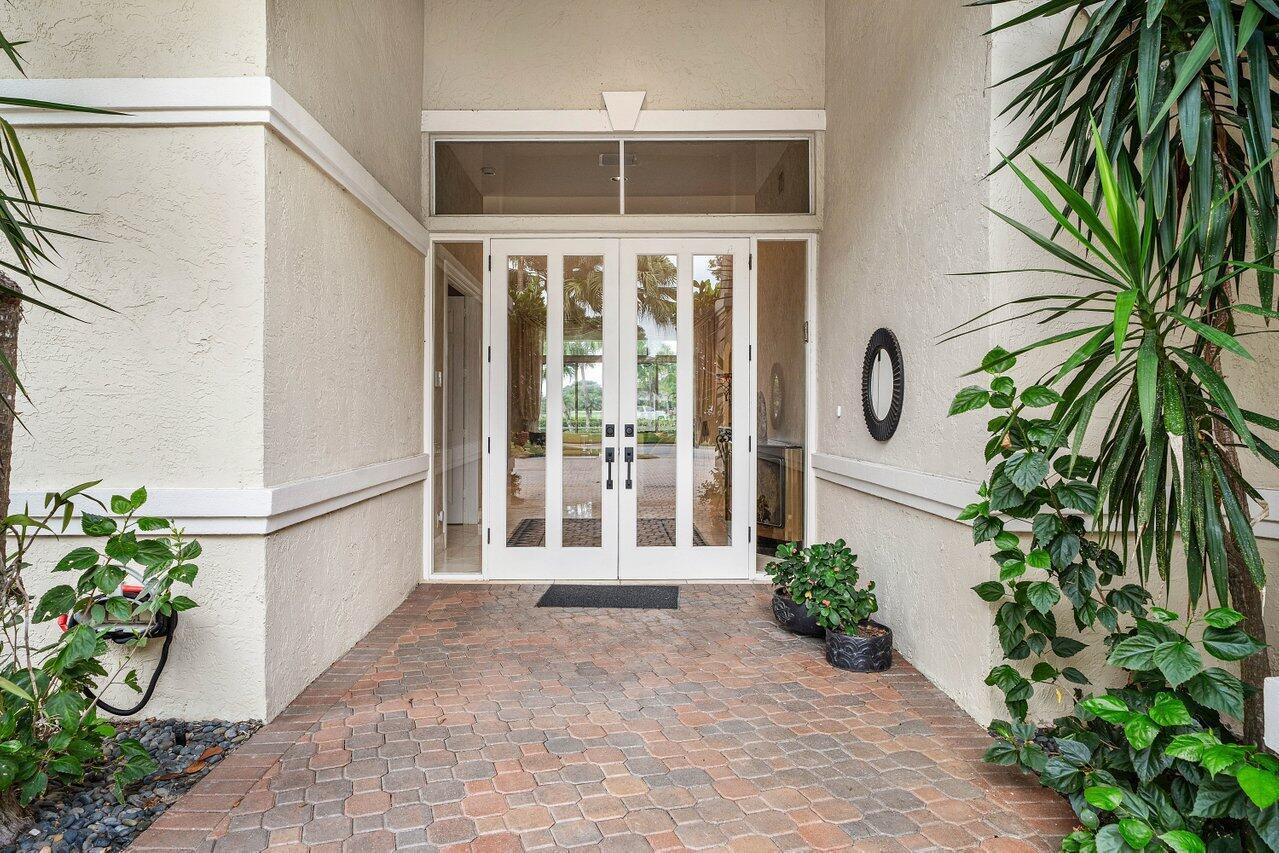 A paved entryway leads to white double doors with glass panels and a transom window — 118 W Village Way, Jupiter FL 33458, JUPITER, FL