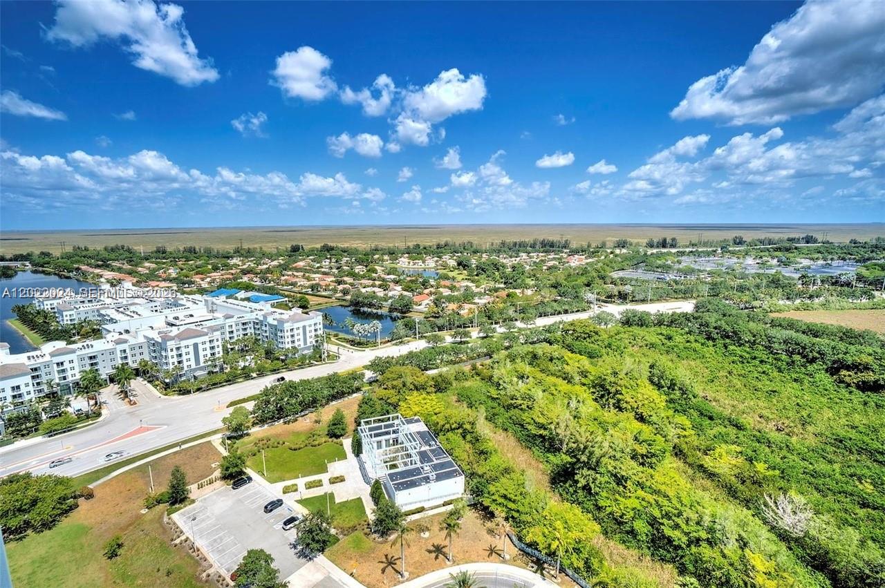 An aerial view shows a residential complex, a parking lot, and surrounding green space — 2000 Metropica Way # 2202, Sunrise FL 33323, SUNRISE, FL
