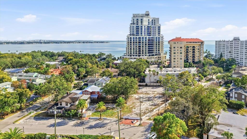 An aerial view shows a vacant lot surrounded by houses, trees, and high-rise buildings — 1401 S DESOTO AVENUE, TAMPA, FL
