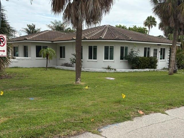 A single-story house with a tiled roof and white exterior sits on a grassy lot — 56 LAUREL STREET, CLEARWATER BEACH, FL