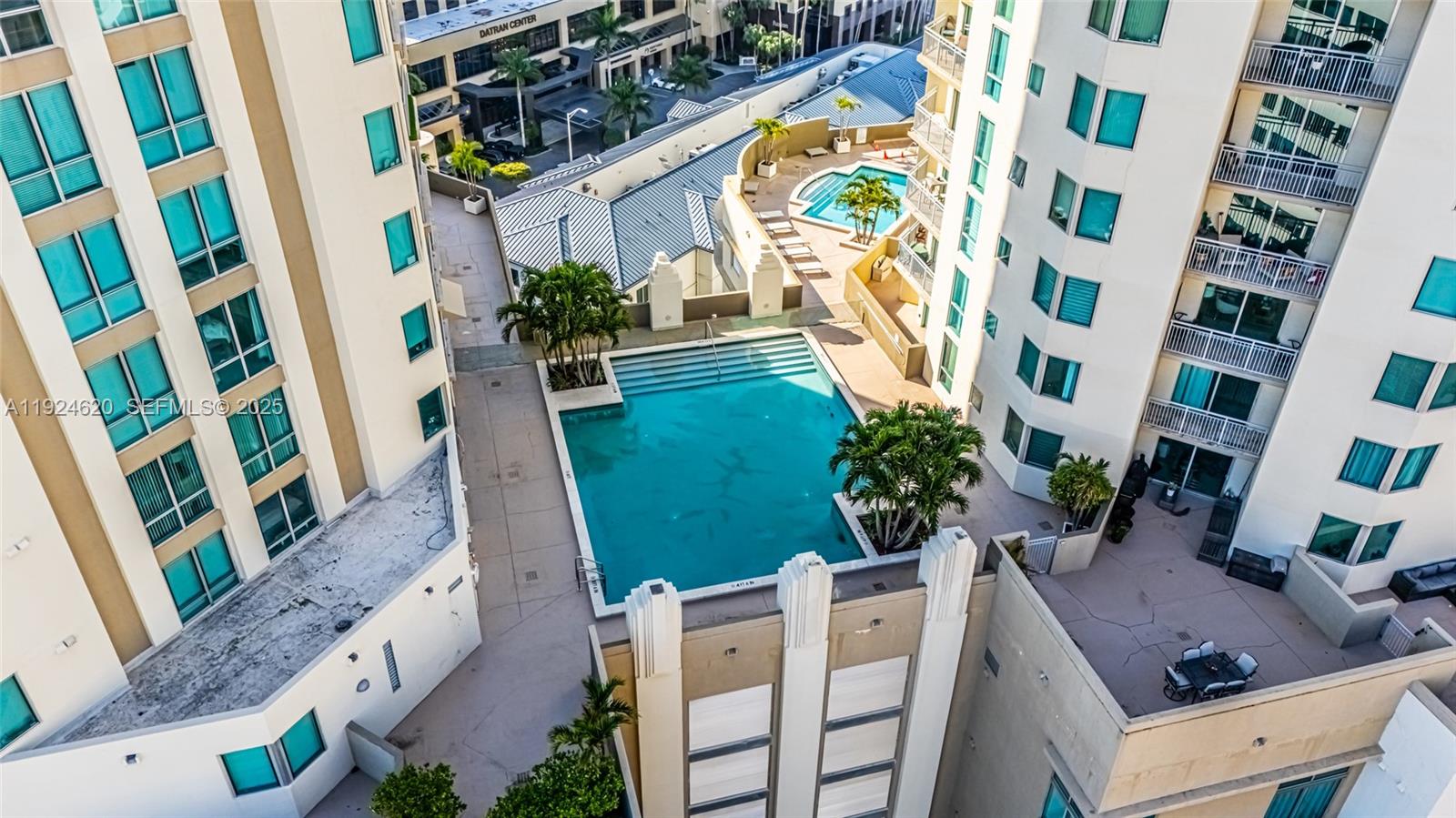 An aerial view shows a swimming pool situated between two tall residential apartment buildings — 9055 SW 73 CT # 809, Miami FL 33156, MIAMI, FL