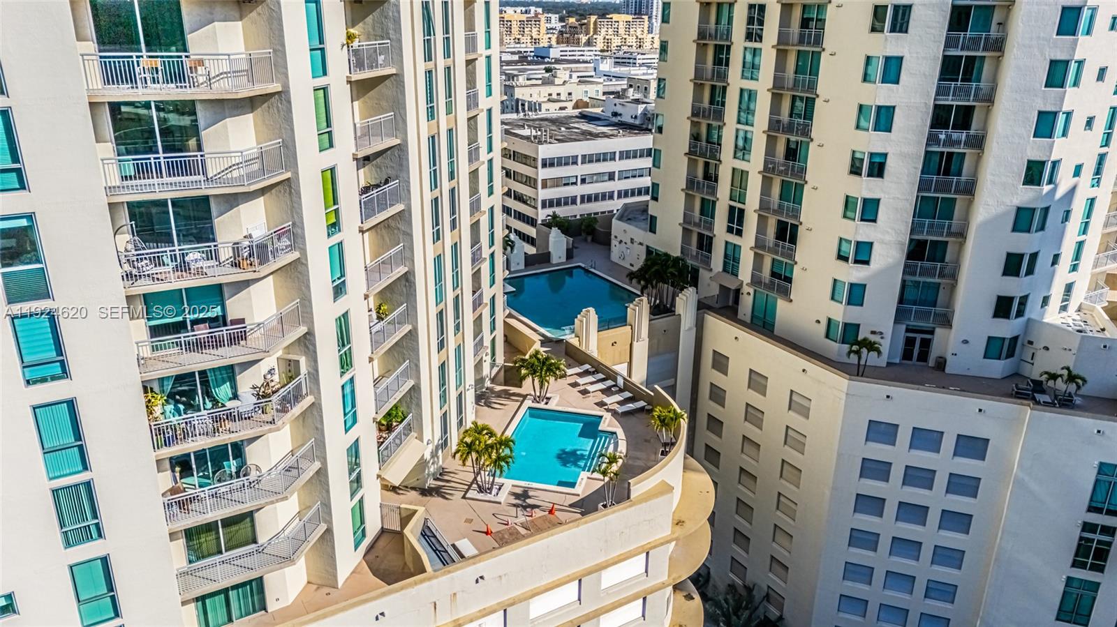 An aerial view shows two high-rise apartment buildings with two outdoor swimming pools between them — 9055 SW 73 CT # 809, Miami FL 33156, MIAMI, FL