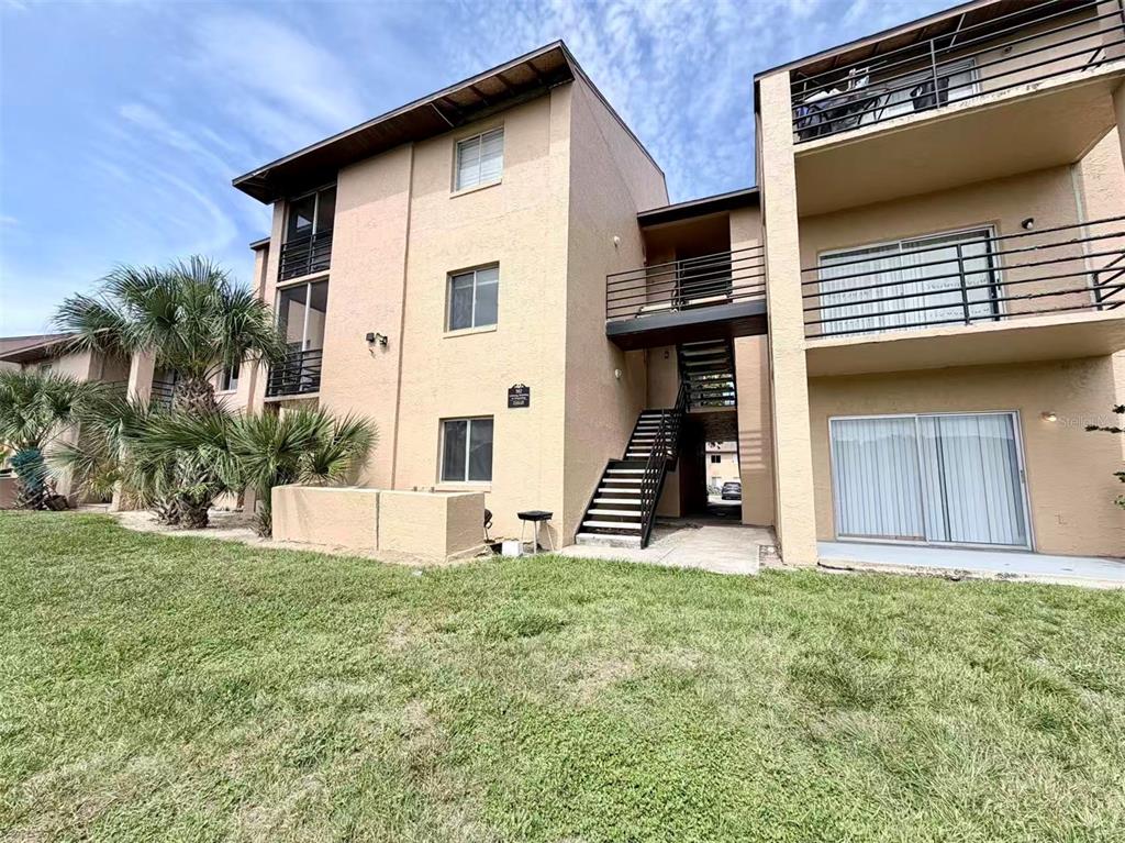 An exterior view of a multi-story apartment building with a metal staircase and balconies — 5226 VIA HACIENDA CIRCLE UNIT A214, ORLANDO, FL