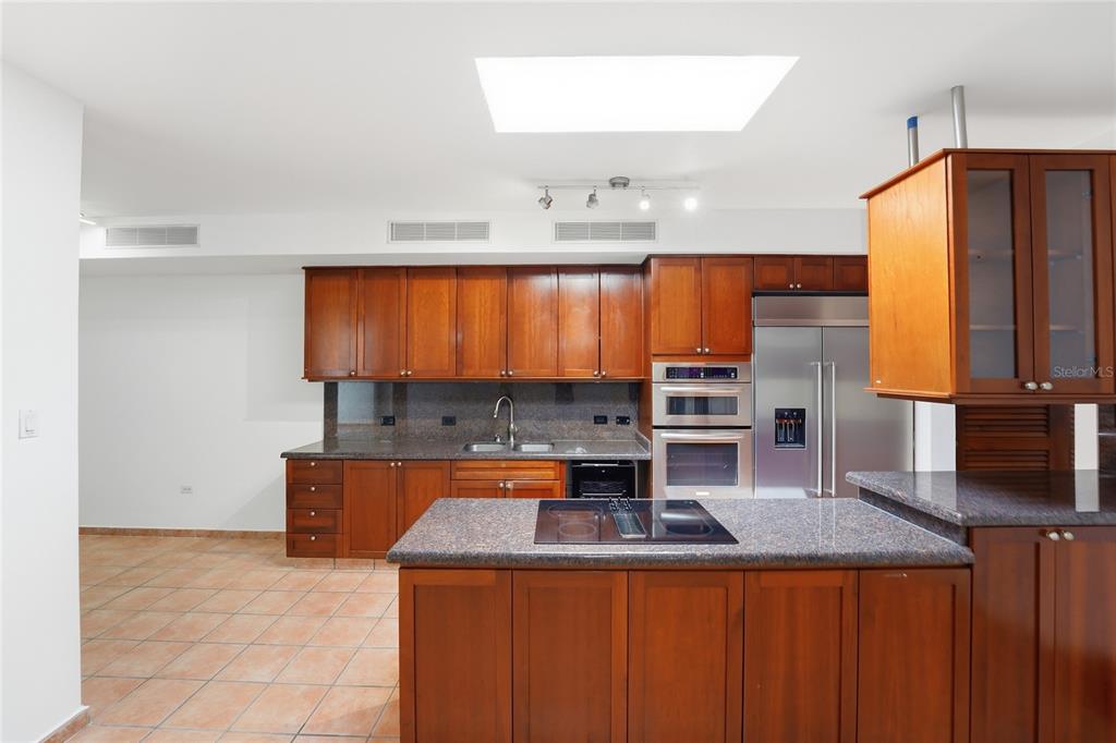 A kitchen features wood cabinets, granite countertops, stainless steel appliances, and a central island — 182 DORADO BEACH EAST, DORADO, PR