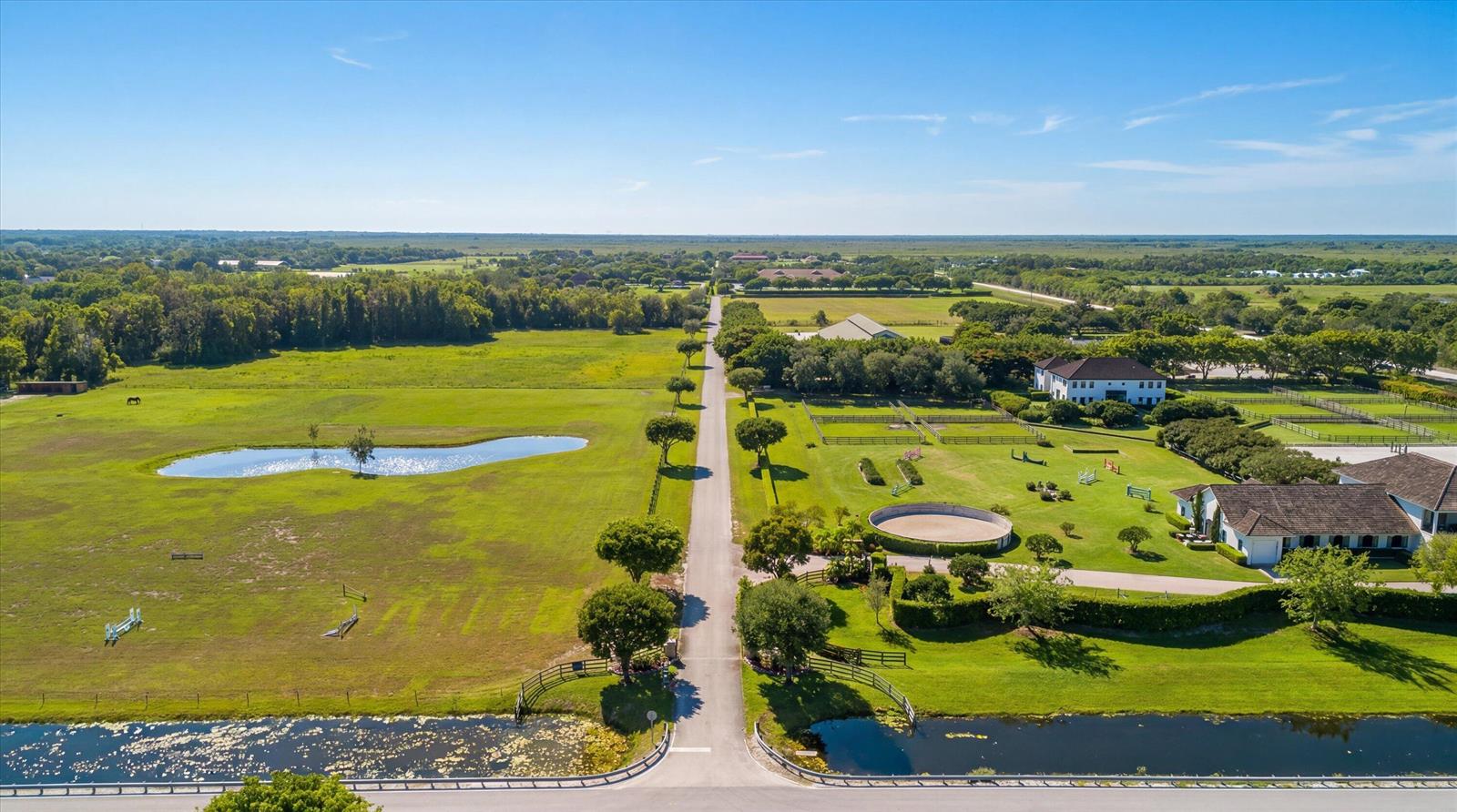 An aerial view of a large rural property featuring a long driveway, pastures, and buildings — 5266 138th Terrace S, Wellington FL 33449, WELLINGTON, FL