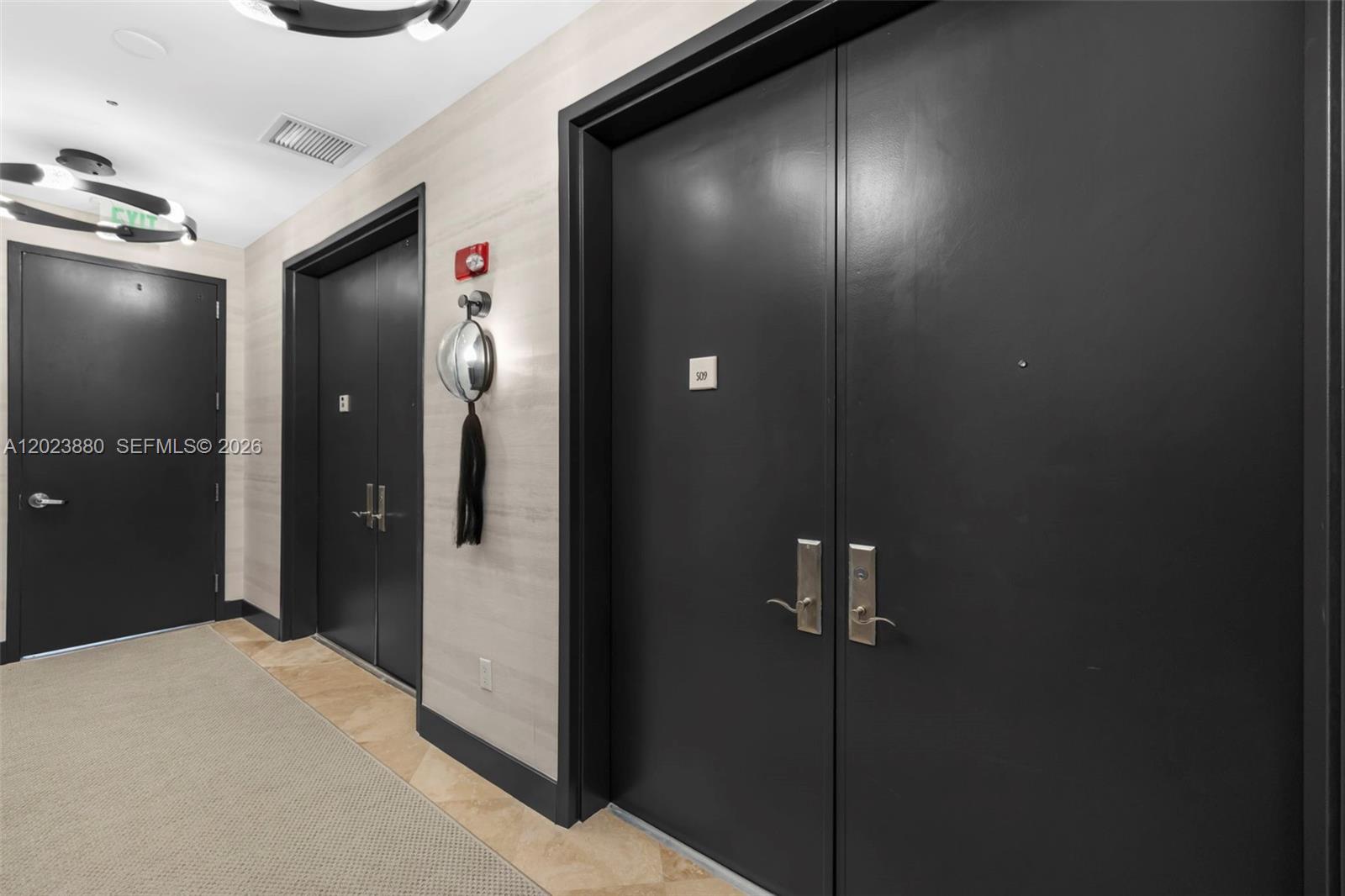 A hallway features dark double doors labeled 509, a single door, and a convex mirror — 100 S Pointe Dr # 509, Miami Beach FL 33139, MIAMI BEACH, FL