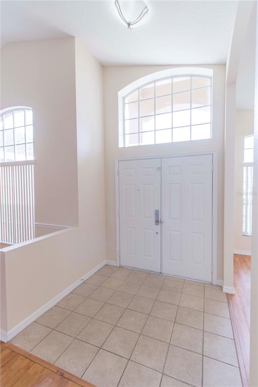 An entryway features a tiled floor, double front doors, and a large arched window above — 2663 GOLD DUST CIRCLE, KISSIMMEE, FL
