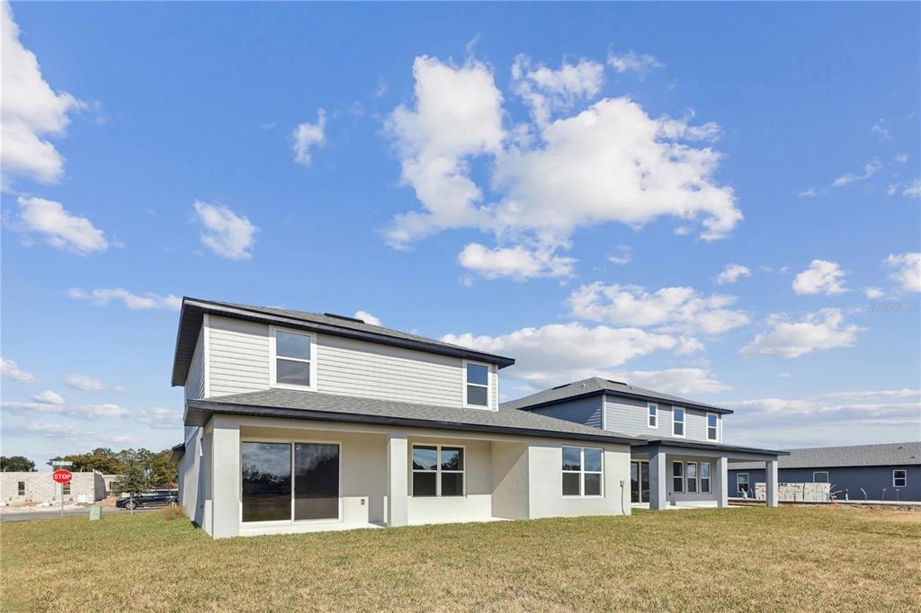 The exterior of a two-story house with light-colored siding and a rear patio — 4488 NW 37TH STREET ROAD, OCALA, FL