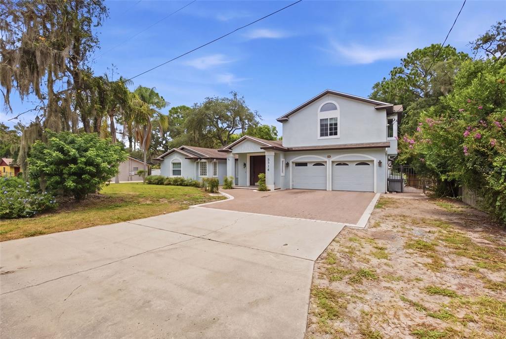 A two-story house with a light blue exterior, a two-car garage, and a paved driveway — 164 E GOODHEART AVENUE, LAKE MARY, FL