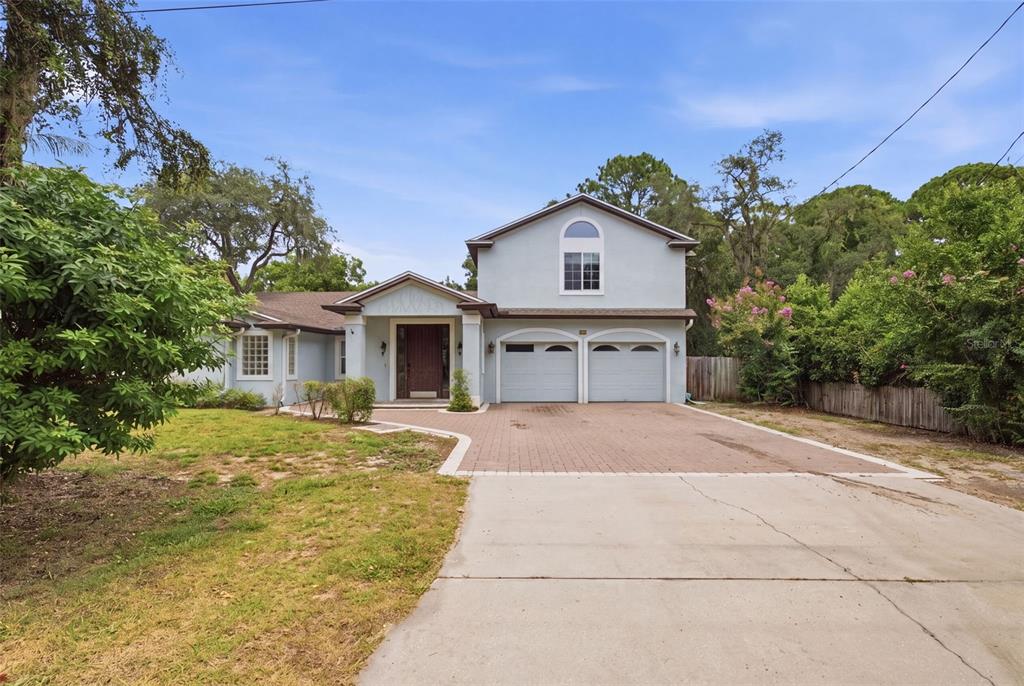 A two-story house with a light blue exterior, a brick driveway, and an attached two-car garage — 164 E GOODHEART AVENUE, LAKE MARY, FL
