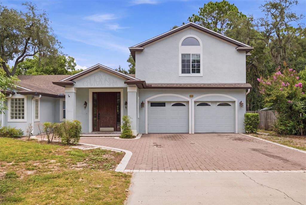 A two-story house with a light blue exterior, a brick driveway, and a two-car garage — 164 E GOODHEART AVENUE, LAKE MARY, FL
