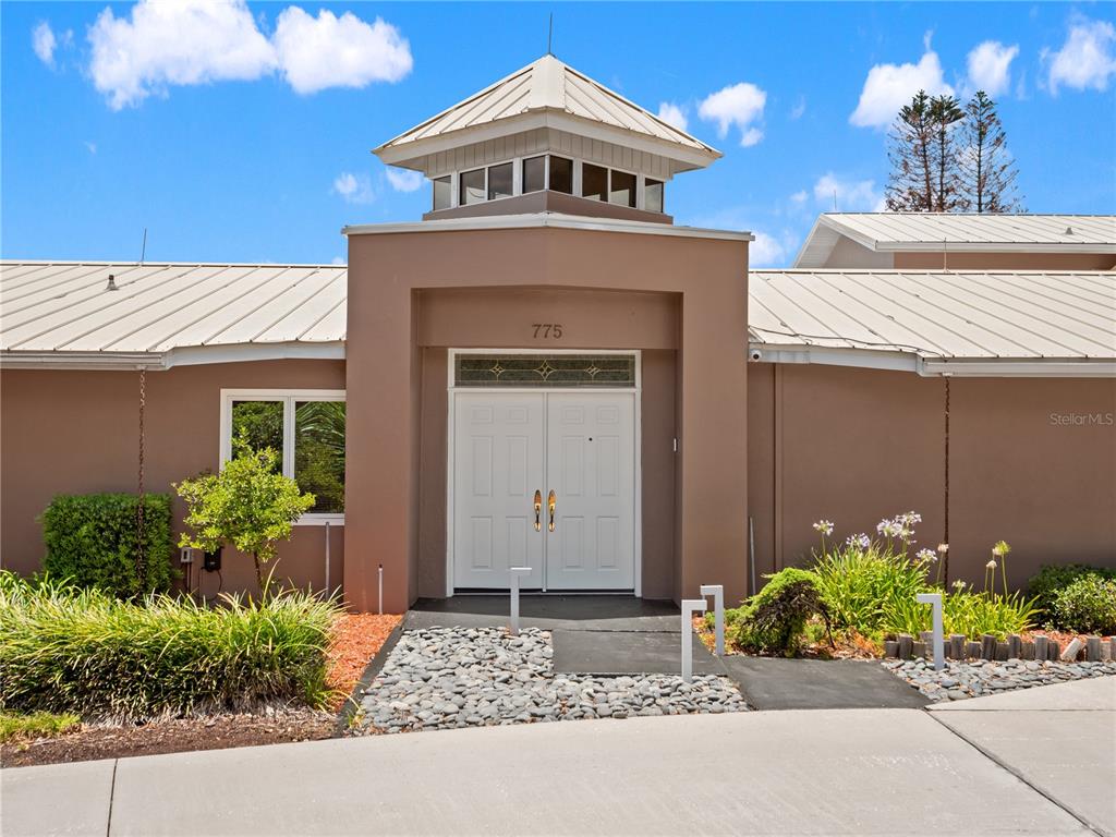 The exterior of a tan building features a central entryway with double doors and a cupola — 775 S ILAKEE AVENUE, LAKE ALFRED, FL