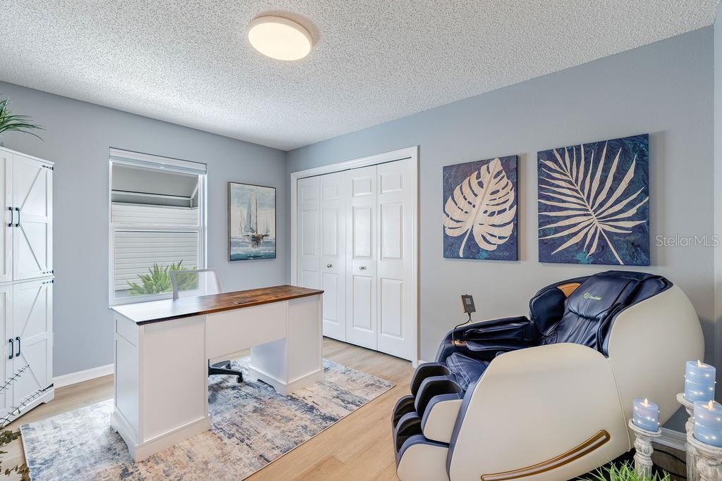 A home office features a white desk, a massage chair, and blue wall art — 8975 SE 168TH TAILFER STREET, THE VILLAGES, FL