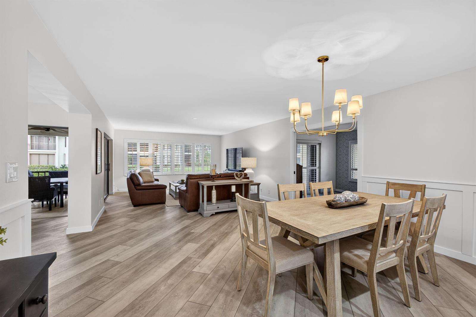 A dining area with a wooden table and chairs opens into a living room — 19149 SE Sea Turtle Court # 105, Jupiter FL 33469, JUPITER, FL