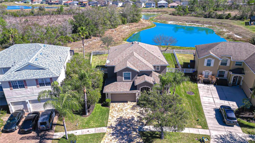 An aerial view of a suburban house with a paved driveway and a backyard pond — 19914 BLUFF OAK BOULEVARD, TAMPA, FL