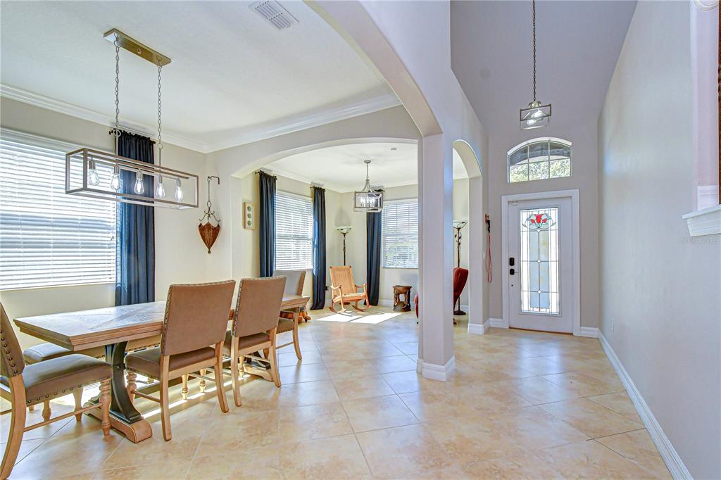 A dining area with a rectangular table and chairs leads into a tiled entryway — 19914 BLUFF OAK BOULEVARD, TAMPA, FL