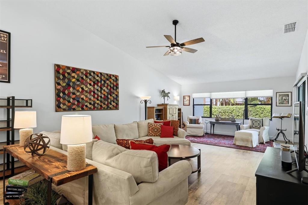 A living room features a beige sectional sofa, a ceiling fan, and large windows — 2644 MOSS OAK DRIVE UNIT 47, SARASOTA, FL