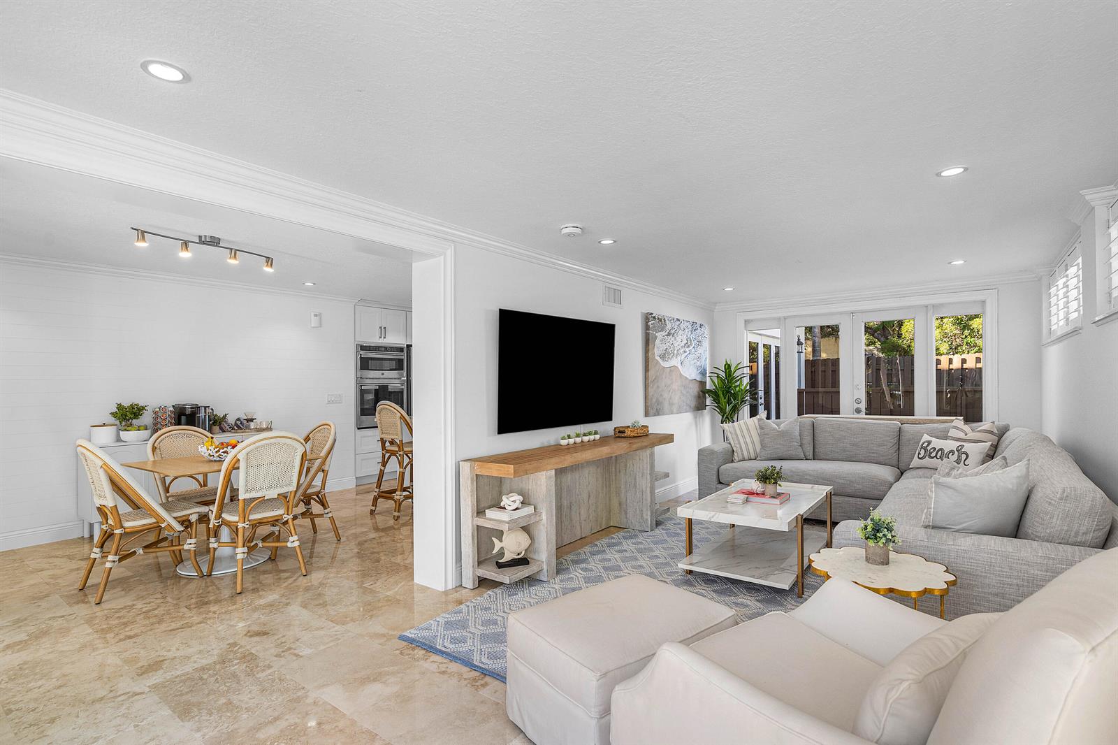 A bright living room and dining area feature light tile floors and neutral coastal decor — 820 Palm Trail, Delray Beach FL 33483, DELRAY BEACH, FL