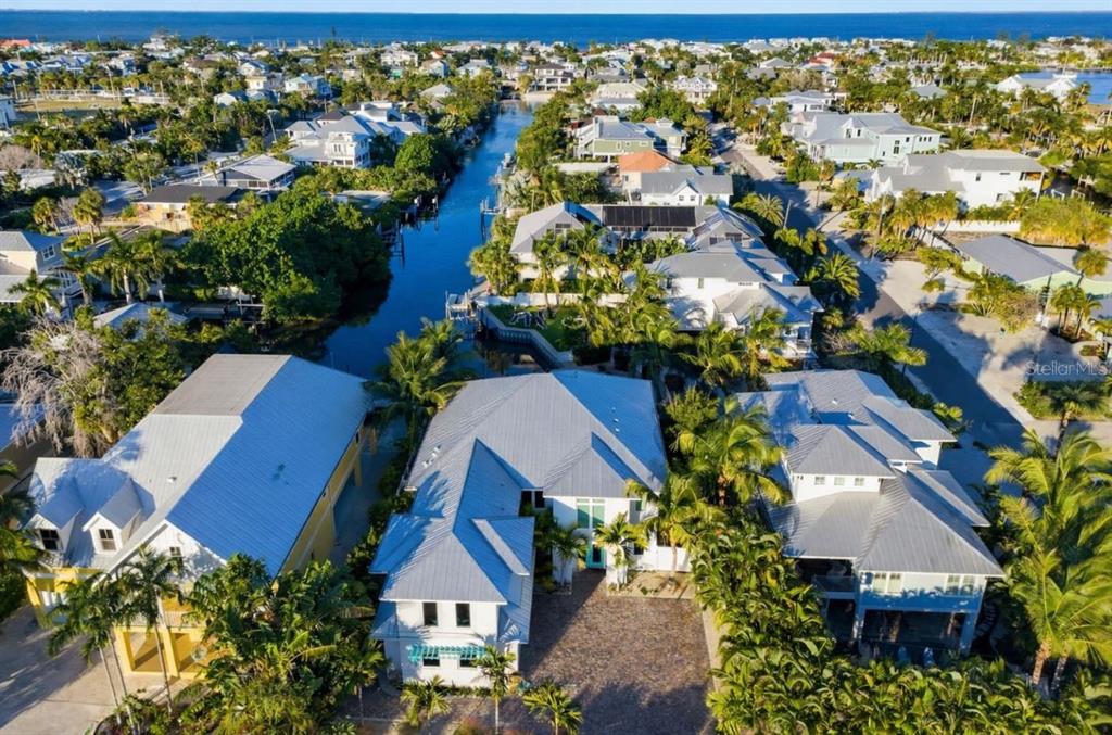 An aerial view of a coastal neighborhood featuring houses with metal roofs along a canal — 50 N SHORE DRIVE, ANNA MARIA, FL