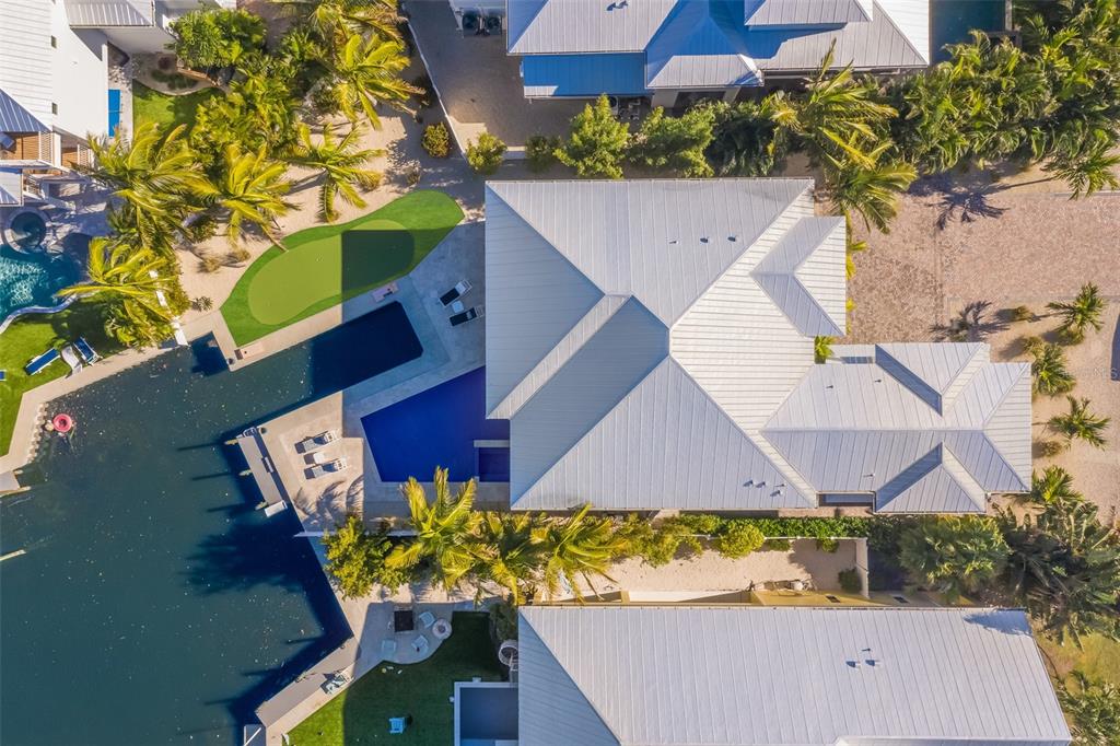 Aerial view of a waterfront house with a swimming pool, putting green, and metal roof — 50 N SHORE DRIVE, ANNA MARIA, FL