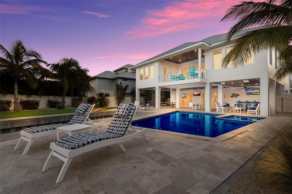 A two-story house with a pool, patio, and lounge chairs at sunset — 50 N SHORE DRIVE, ANNA MARIA, FL