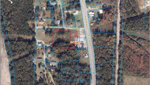 This aerial map shows a vacant parcel of land outlined in red near a highway — HOWARD STREET, CENTURY, FL