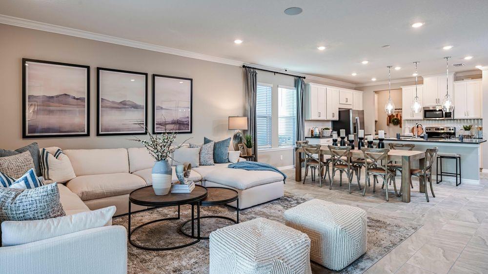 An open-concept living room and kitchen featuring a large sectional sofa and dining area — 6917 PRAIRIE OAK WAY, NOKOMIS, FL