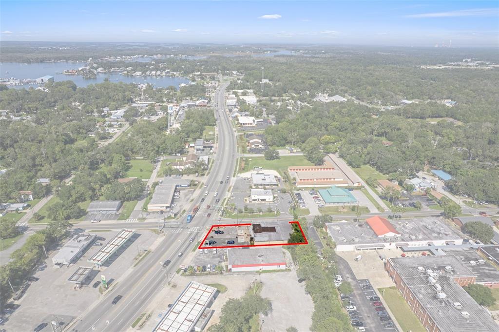 An aerial view shows a commercial property outlined in red along a busy road — 669 NE US HIGHWAY 19, CRYSTAL RIVER, FL
