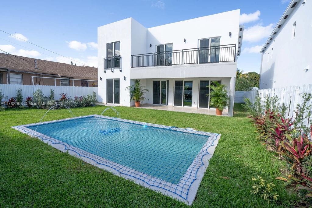 A two-story white modern house features a backyard swimming pool with a safety net — 910 SW 24th Rd, Miami FL 33129, MIAMI, FL
