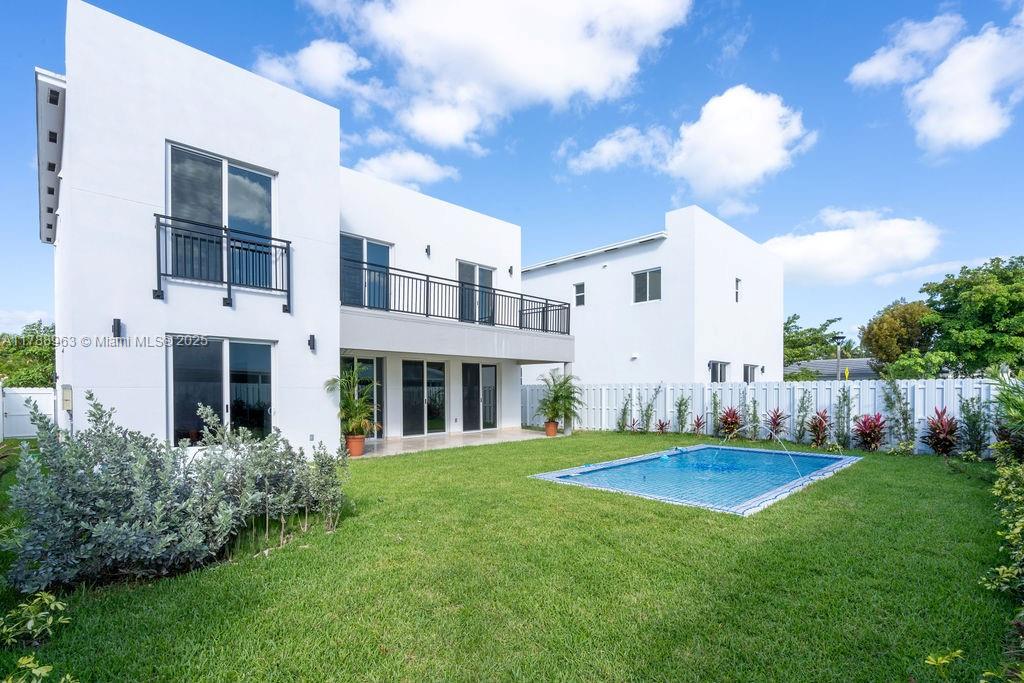 A modern white two-story house with a balcony overlooks a backyard swimming pool — 910 SW 24th Rd, Miami FL 33129, MIAMI, FL