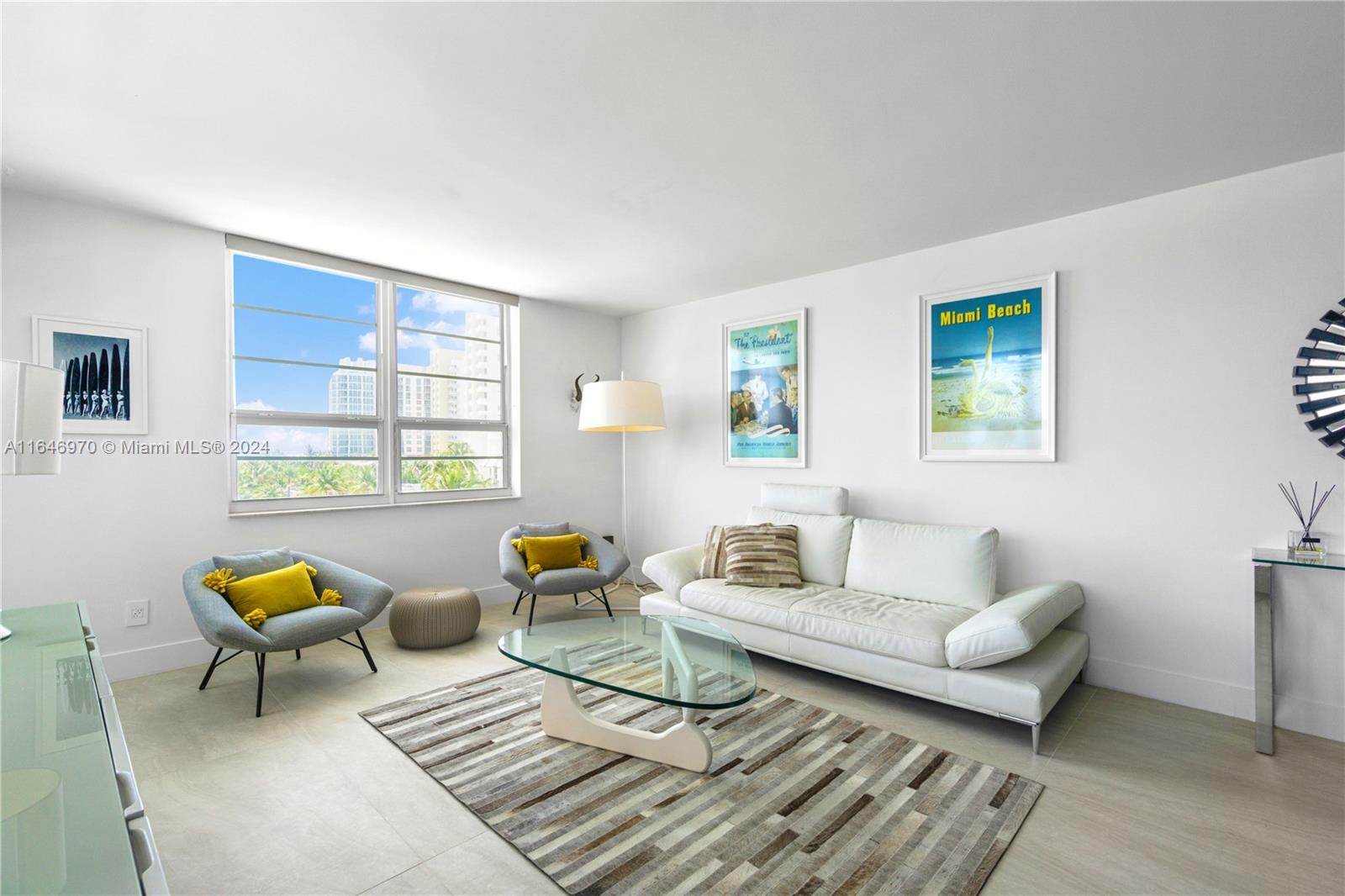 A bright living room features a white sofa, glass coffee table, and two grey armchairs — 100 Lincoln Rd # 548, Miami Beach FL 33139, MIAMI BEACH, FL
