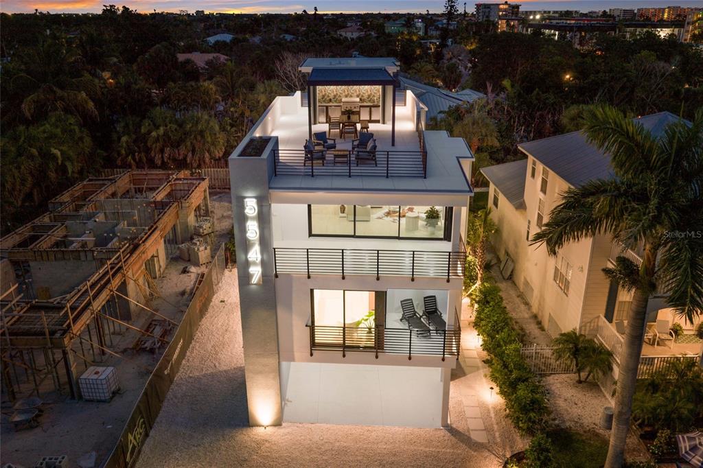 An aerial view of a modern three-story house with balconies and a rooftop terrace — 5547 AVENIDA DEL MARE, SARASOTA, FL