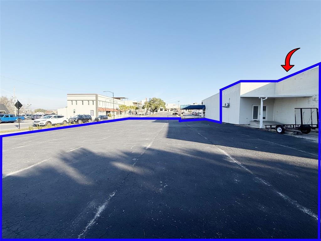A paved parking lot sits in front of a commercial building with a white exterior — 205 S MAGNOLIA AVENUE, OCALA, FL