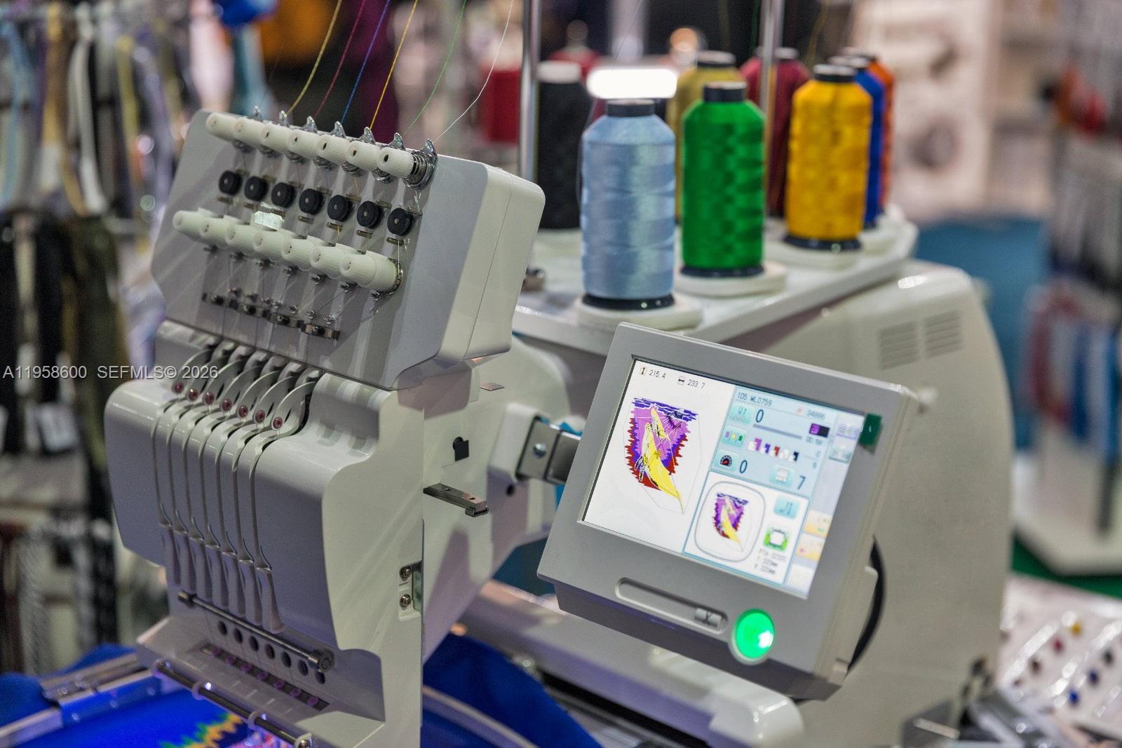A close-up view of a multi-needle embroidery machine with thread spools and a digital display — 8400 NW 33rd St, Doral FL 33122, DORAL, FL