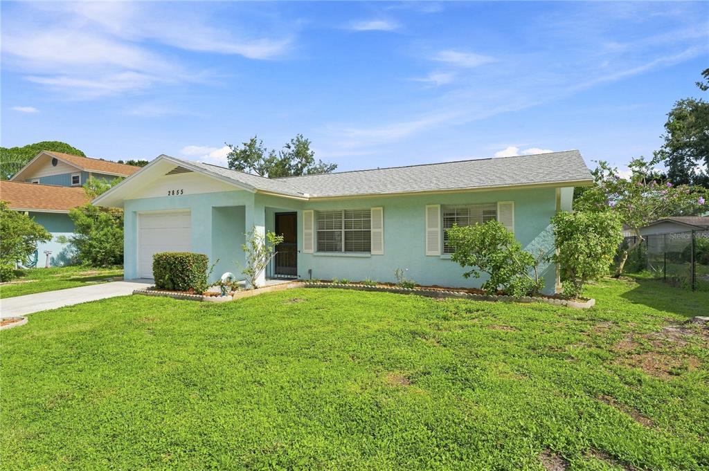 A light blue, single-story house with a white garage door and a grassy front yard — 2855 DUEBY STREET, SARASOTA, FL