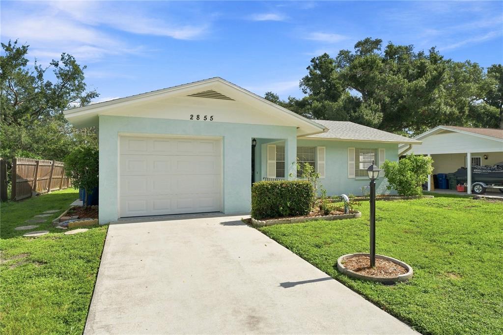A light blue single-story house with a garage, concrete driveway, and a front lawn — 2855 DUEBY STREET, SARASOTA, FL
