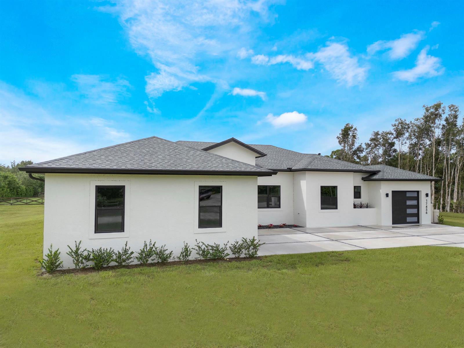 A backyard features a rectangular swimming pool enclosed by a black mesh safety fence — 17436 71st Lane N, Loxahatchee FL 33470, LOXAHATCHEE, FL
