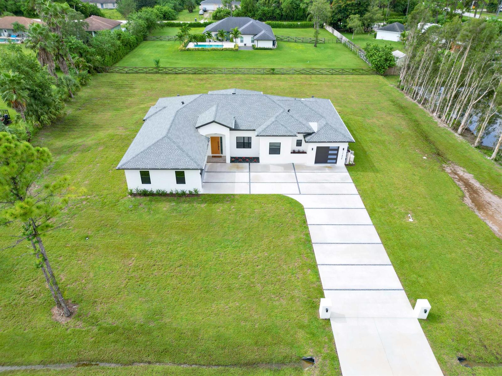 A covered outdoor patio features a built-in grill, sink, tile flooring, and a swimming pool — 17436 71st Lane N, Loxahatchee FL 33470, LOXAHATCHEE, FL