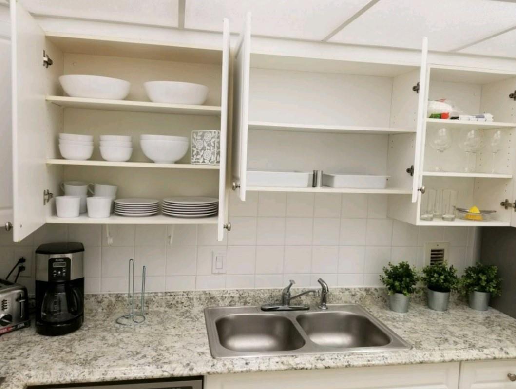 A kitchen features white cabinets, a double stainless steel sink, and speckled granite countertops — 3801 S Ocean Drive # 7Q, Hollywood FL 33019, HOLLYWOOD, FL