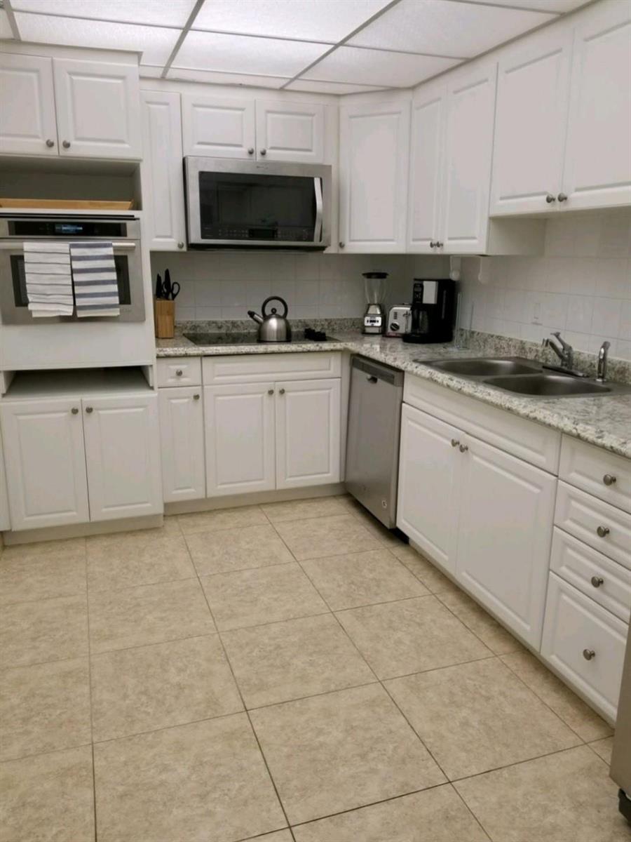 A kitchen with white cabinets, stainless steel appliances, granite countertops, and light tile flooring — 3801 S Ocean Drive # 7Q, Hollywood FL 33019, HOLLYWOOD, FL