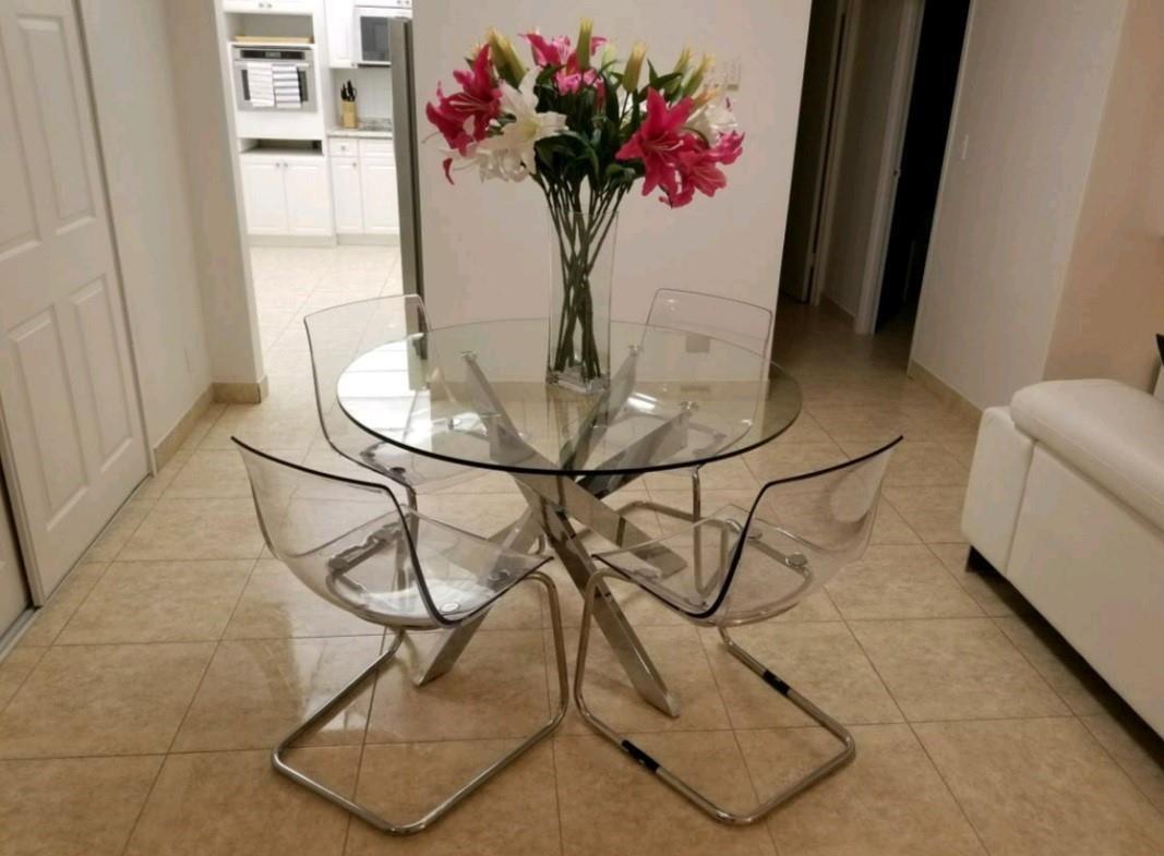 A glass dining table with four clear acrylic chairs sits on a tiled floor — 3801 S Ocean Drive # 7Q, Hollywood FL 33019, HOLLYWOOD, FL